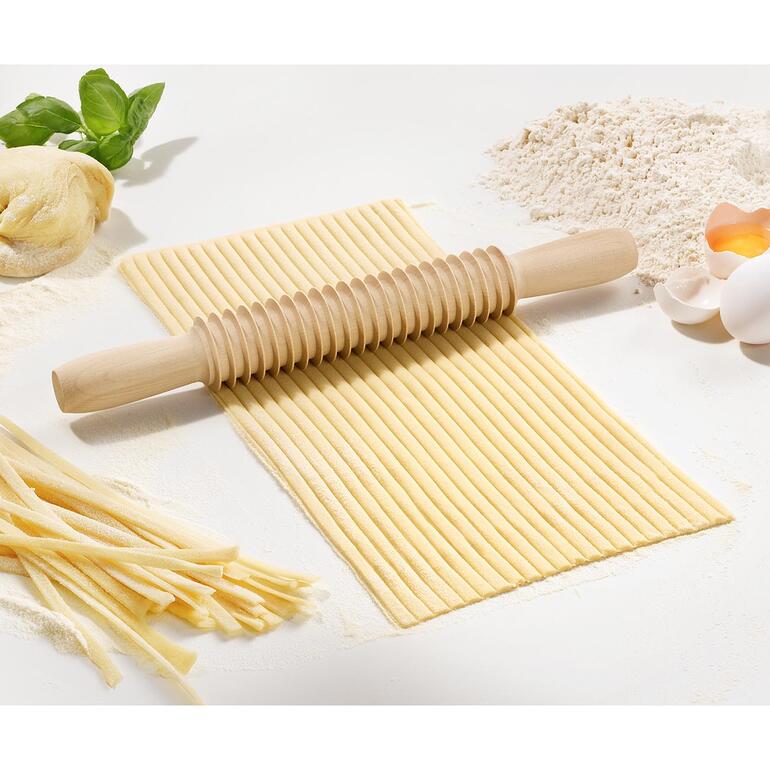 Perfekt auch der 7 mm-Fettuccine-Schneider. Hölzerner Spaghetti- oder Fettuccine-Schneider auf einer sauberen Arbeitsfläche.