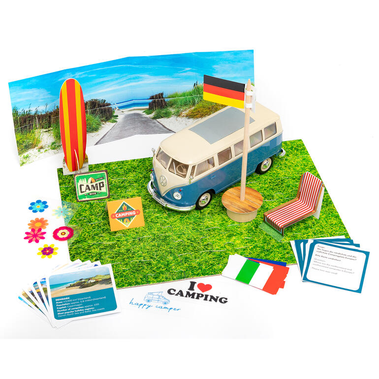 Adventskalender Bausatz VW Bulli T1, Maßstab 1:24 VW Bulli T1 Modell umgeben von Campingzubehör auf grünem Untergrund.