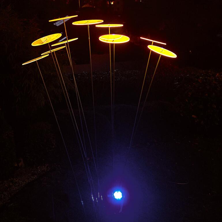 Solarleuchte mit mehreren gelben Platten im Dunkeln.