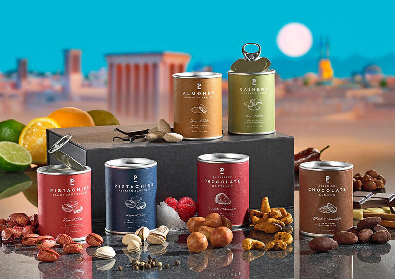 Genießerbox mit verschiedenen Snacks und Nüssen mit Akropolis-Hintergrund.