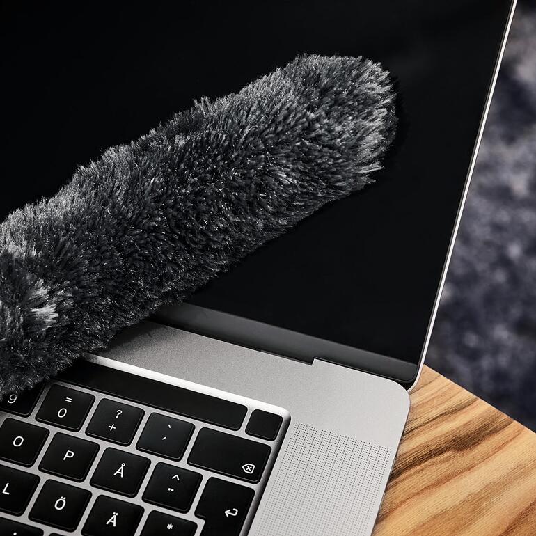 Duster Kit reinigt einen Laptop-Bildschirm.