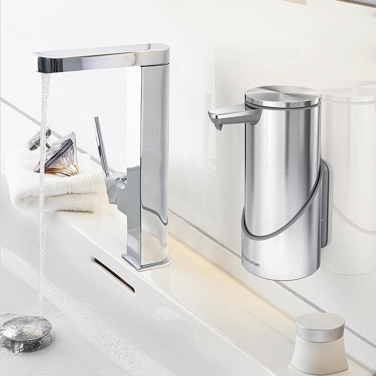 Wandhalterung für Sensor-Seifenspender neben einem Waschbecken.