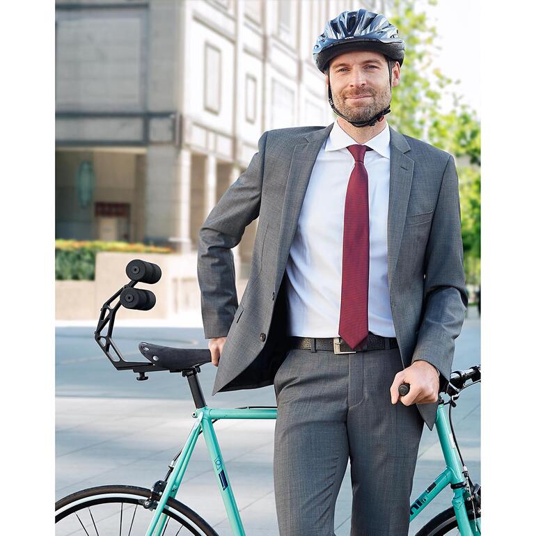 Mann in Anzug steht mit Fahrrad und Tshobo Fahrrad-Rückenstütze im Freien.