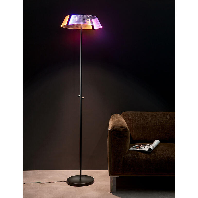 Design-Stehleuchte 2.0 vor schwarzer Wand neben Couch