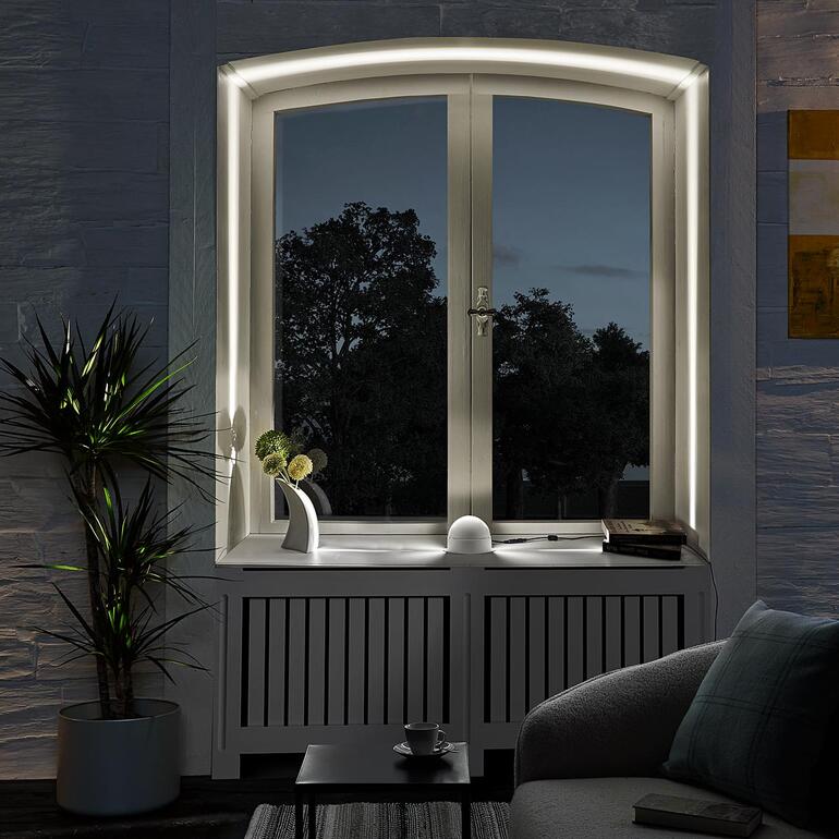 LED-Rahmen-Effektleuchte am Fenster mit Blick auf einen Garten