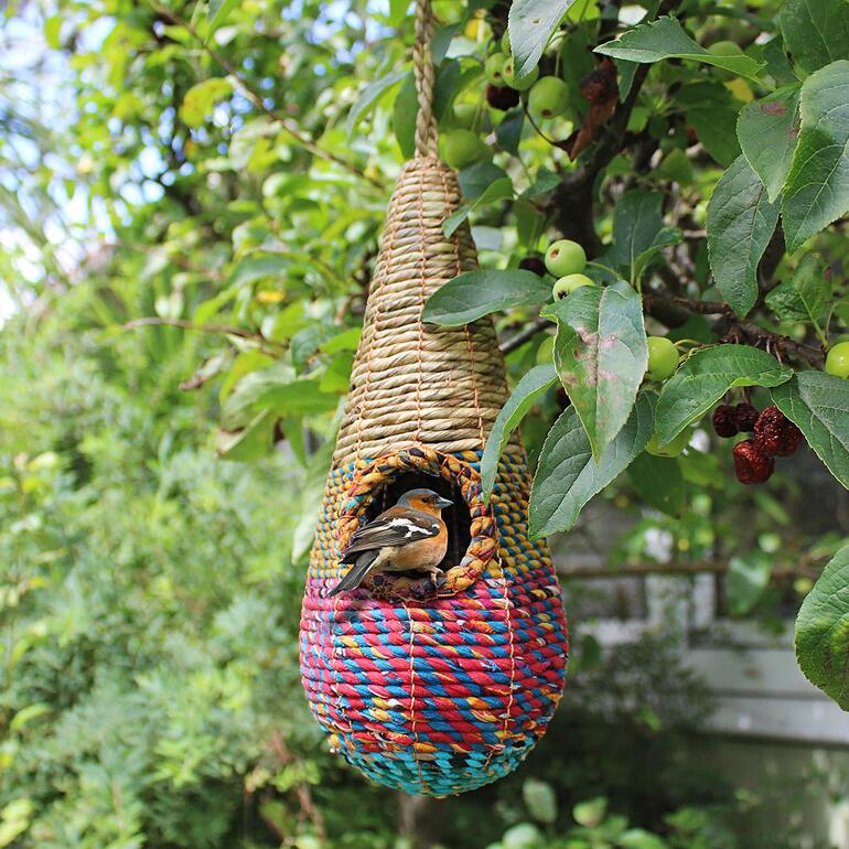 Artisan Vogelnest aus geflochtenem Material, hängend an einem Baum