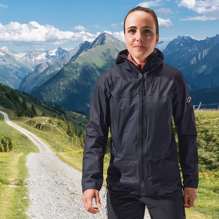 Frau trägt Berghaus Hyper Alpha Outdoorjacke in den Bergen.