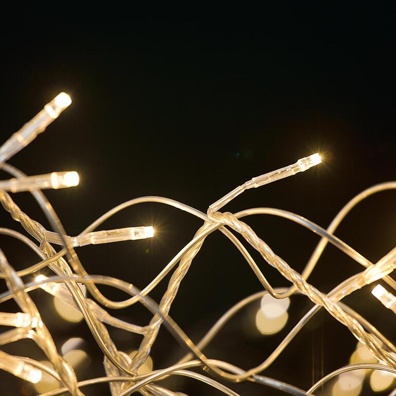 Ideal auch als glitzernder Blickfang an Ihrer Eingangstüre. Nahaufnahme der Lichter eines LED-Deko-Kranzes.