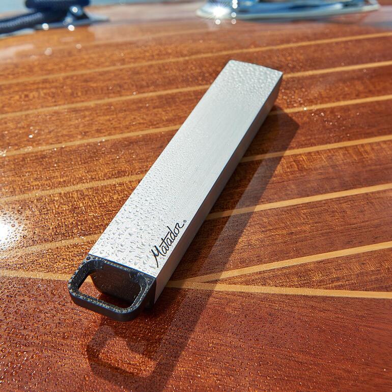 Wasserdichte Pillendose auf einem Holzboot-Tisch mit Wassertropfen.