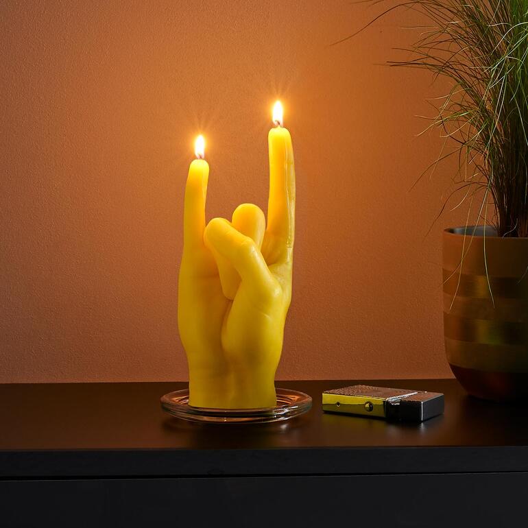 Rock you, gelb Gelbe Handgestenkerze in Rocker-Geste auf einem Tisch.