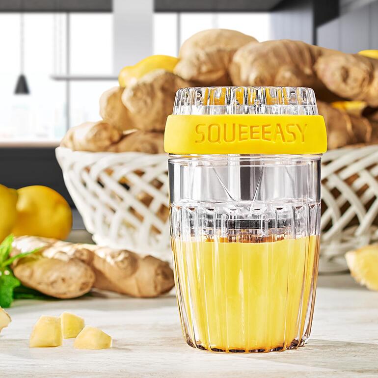 Squeeeasy® Ingwerpresse mit frisch gepresstem Ingwersaft und Ingwerstücken.