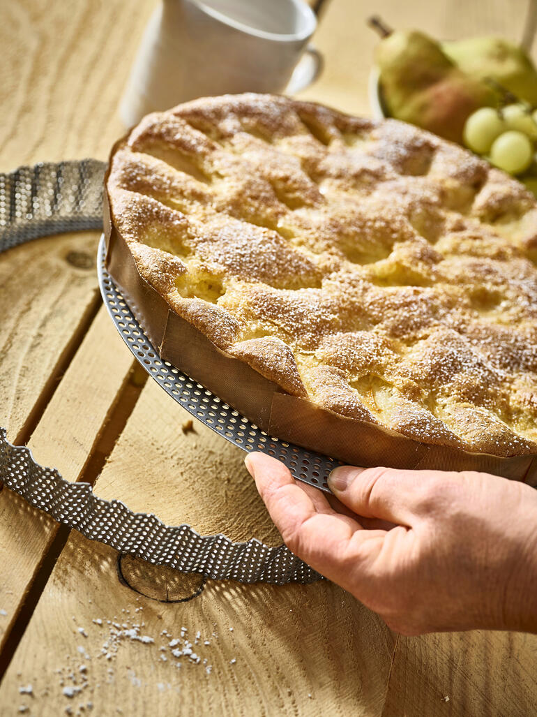 Perforierte Edelstahl-Backform mit frisch gebackenem Kuchen.