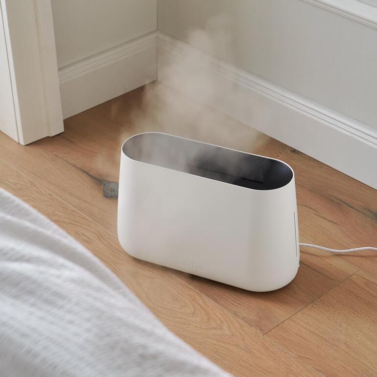 Weiß 3-in-1 Luftbefeuchter BEN in Gebrauch mit Dampf in einem Schlafzimmer.