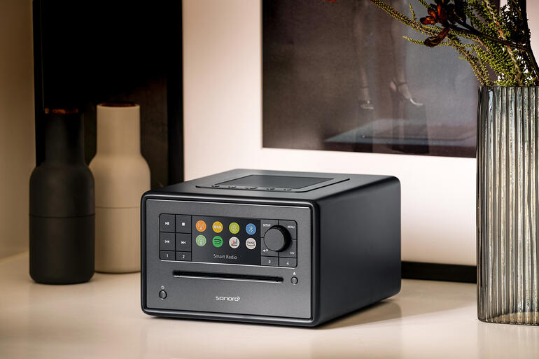 Kompakt-Musiksystem sonoro ELITE in Schwarz auf einem Sideboard mit dekorativen Vasen
