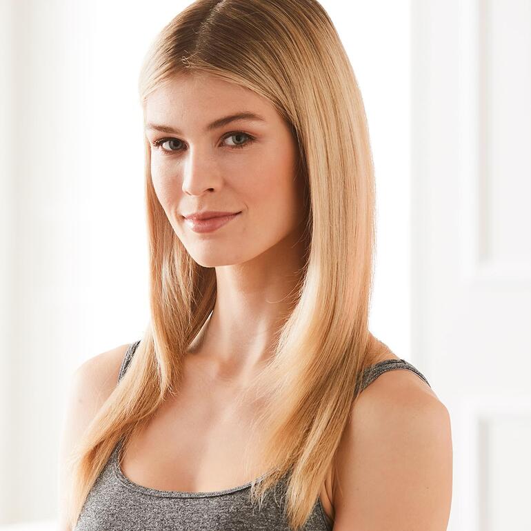 Ihre Frisur gelingt perfekt und spielend leicht – egal ob Wellenstyle oder Sleek-Look. Frau mit glattem Haar lächelt in die Kamera.