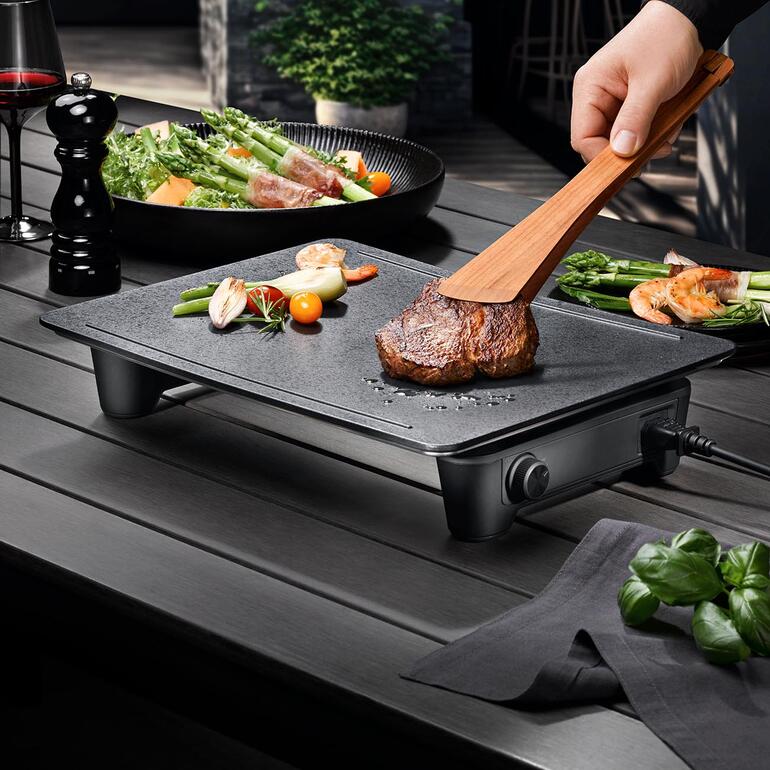Design-Tischgrill Magic mit Steak und Gemüse auf dem Grill.