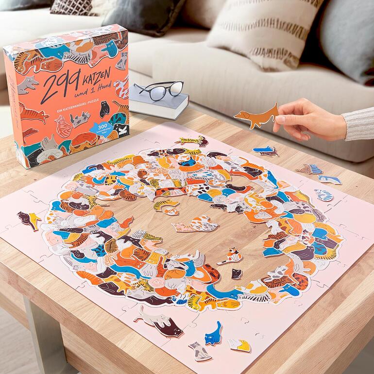 Bunte Tierpuzzle mit vielen Katzen- und Hundeteilen auf einem Tisch.