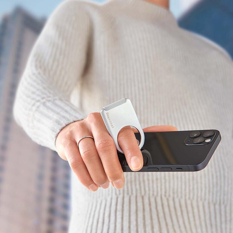 Zum Telefonieren, Lesen, Tippen halten Sie Ihr Smartphone stets sicher und entspannt im Griff. Person hält Smartphone mit Ringhalter in der Hand.