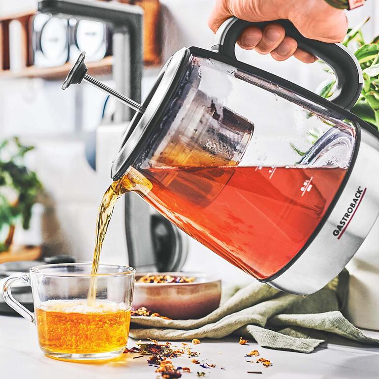 Person gießt frischen Tee aus einer Gastroback Teekanne in eine Tasse.