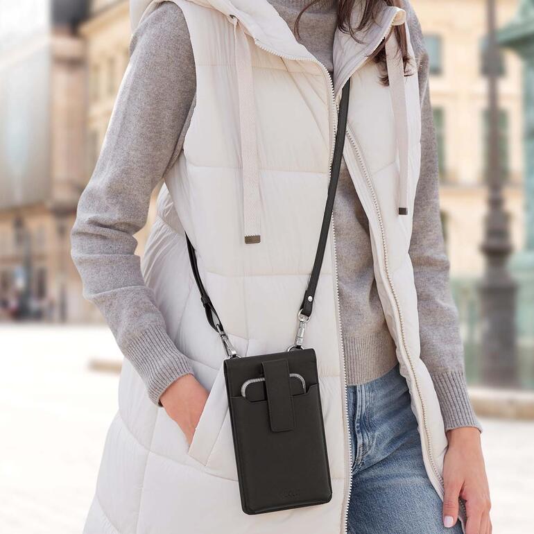 Frau trägt eine schwarze Crossbody-Smartphone-Tasche.
