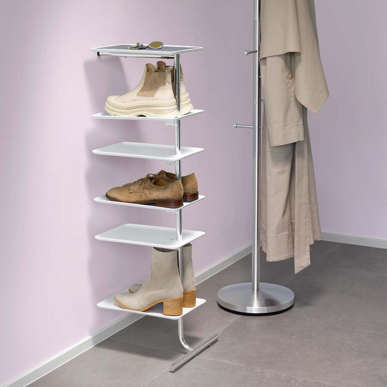 Anlehnregal mit Schuhen und Mantel im Flur.