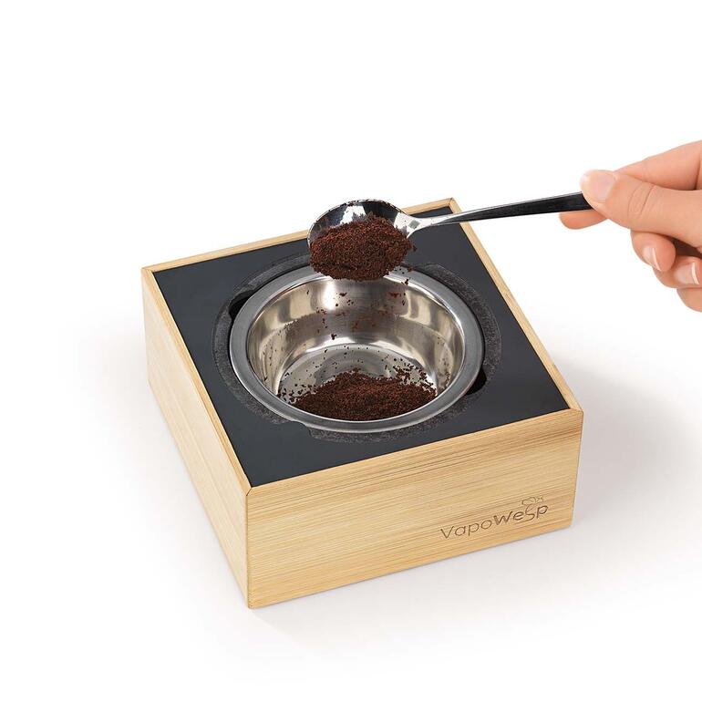 Einfach in der Edelstahl-Brennschale 1 TL Kräutermischung mit 2 TL Kaffeepulver mischen, anzünden und die Box verschließen. Räucherbox VapoWesp mit einer Hand, die Kaffeepulver einfüllt.