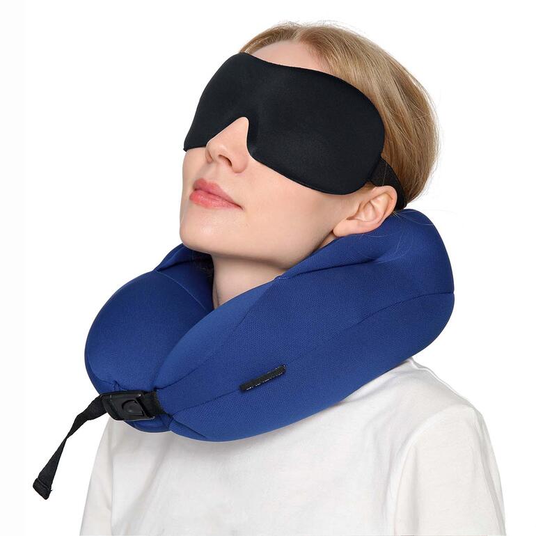 Frau trägt 3D Kontur-Schlafmaske und Nackenkissen im Flugzeug