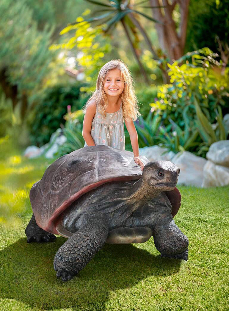 Galapagos Tortoise Mädchen reitet auf einer Galapagos-Schildkröte