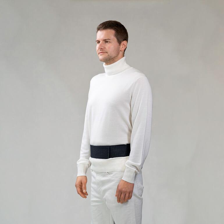 Mann mit Moorkissen um die Taille, steht entspannt