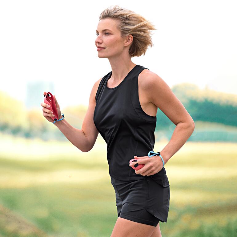 Frau joggt im Freien, trägt sportliche Kleidung und hält eine Laufmaus in der Hand.