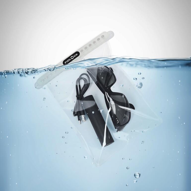 Transparente Dry Bag mit einem Kabel und einer Brille im Wasser.
