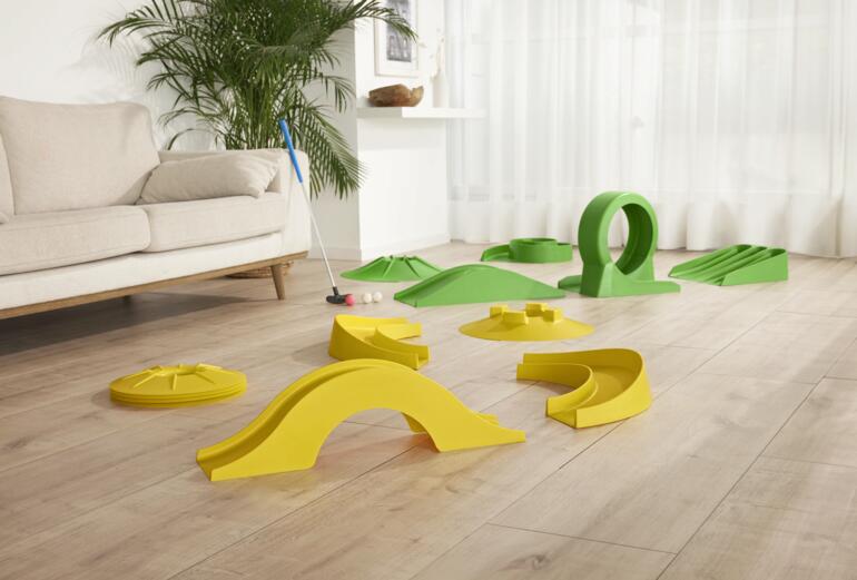 Ein Vergnügen auch drinnen für die ganze Familie, mit Freunden – oder als Pausenspaß im Büro. 17-teiliges Minigolf-Set für drinnen, ohne Bahn, auf einem Holzboden.