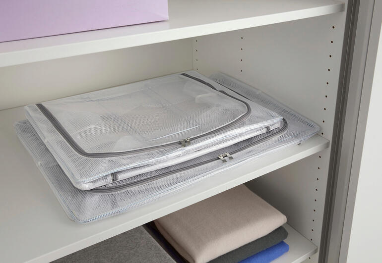 Die Boxen sind bei Nichtgebrauch flach faltbar und platzsparend zu verstauen. Faltbare Aufbewahrungsbox, zusammengefaltet auf einem Regal.