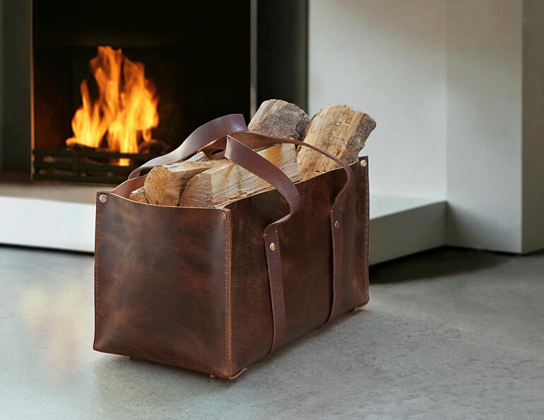 Universal-Ledertasche aus Büffelleder mit Holzscheiten vor einem Kamin.