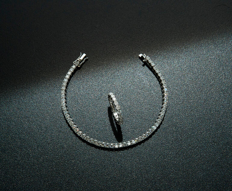 Tennisarmband und -ring, rhodiniert Moissanite-Ringe auf schwarzem Untergrund