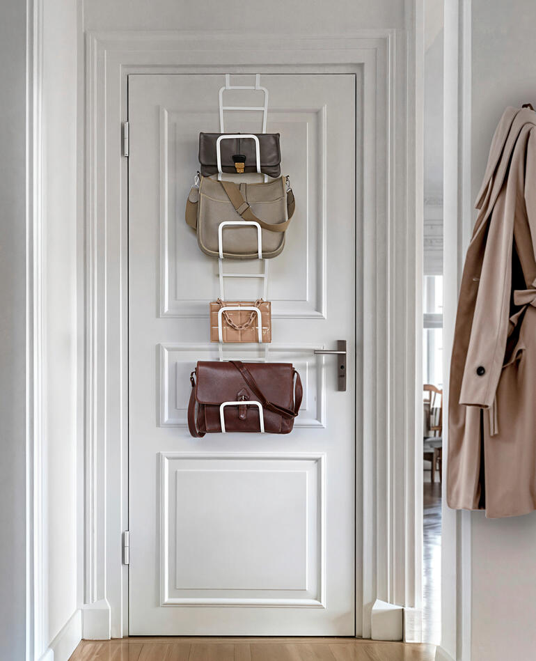 Variable Taschengarderobe hängt an einer Tür mit Taschen.