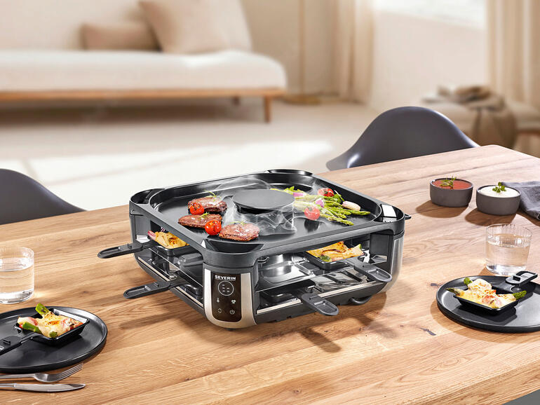 Raclette-Grill mit eingebautem Rauchabzug auf einem Tisch gedeckt.