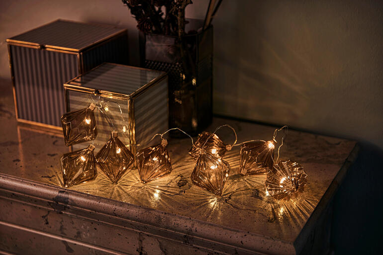 Rauten, Braun Glasornament-Lichterkette mit braunen Rauten auf einem Tisch.