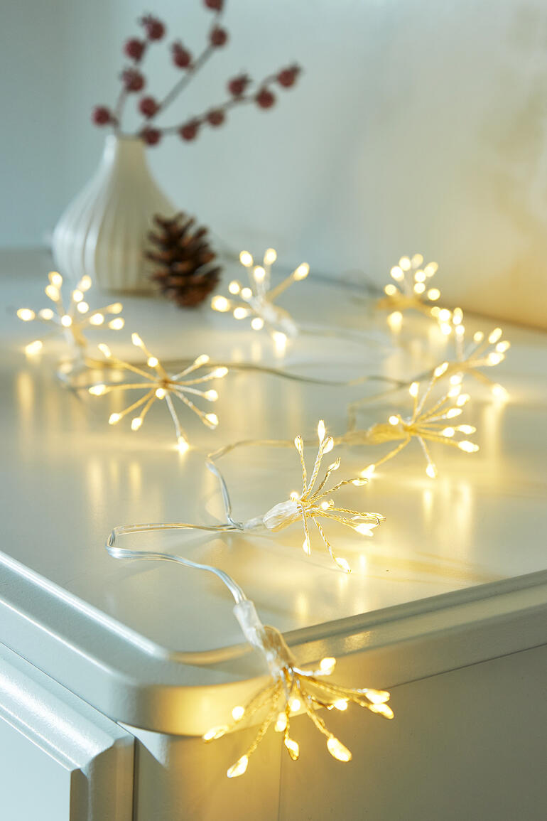 Das ganze Jahr ein vielseitiger, reizvoller Blickfang auf Sideboard, Kaminsims, Fensterbank, ... Lichterkette mit warmen, goldenen Lichtern auf einem Tisch dekoriert.