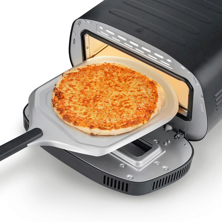 Lieferung inklusive Cordierit-Backstein und Pizzaschieber. Pizza auf einem Pizzaschieber, wird in den 430 °C Pizzaofen geschoben