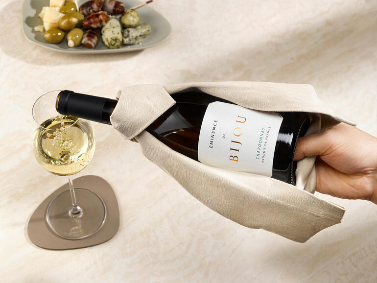 Die Flasche liegt beim Einschenken rutschsicher in der Hand – und nichts tropft auf den Tisch. Hand, die eine Flasche Wein aus dem Wein-Cape nimmt.