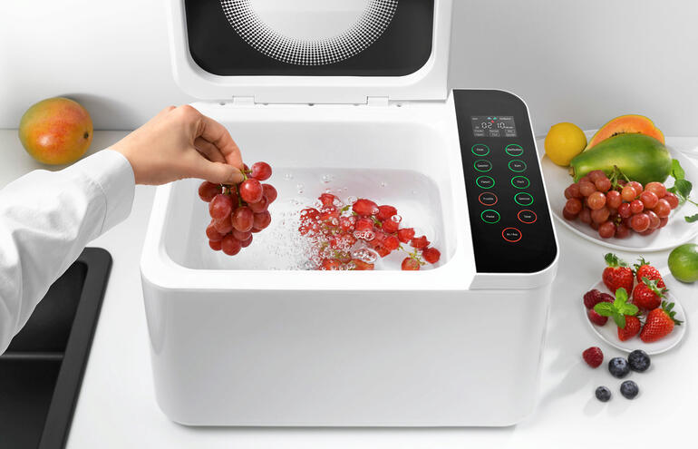 Einfach z. B. Obst einlegen und das entsprechende Programm auswählen – schon startet der Reinigungsvorgang. Hand greift nach Trauben in Food Washer, während Wasser sprudelt.