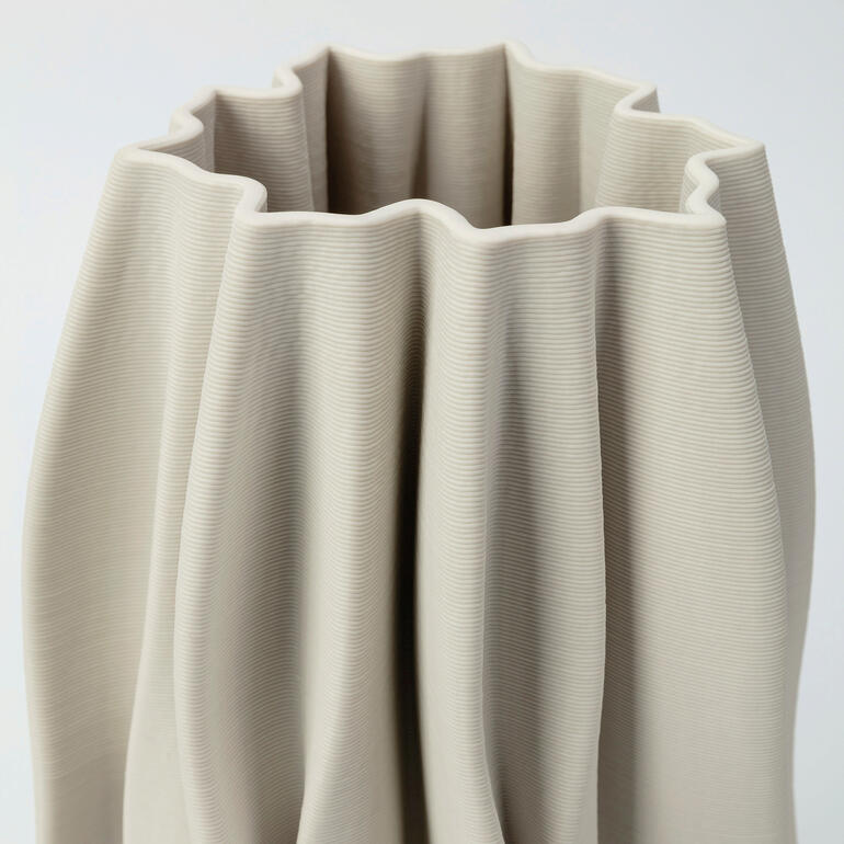 Die charakteristische Plissee-Optik aus hochwertiger Keramik setzt Ihre Blumenarrangements besonders edel in Szene. Detailansicht einer 3D-gedruckten Keramikvase.
