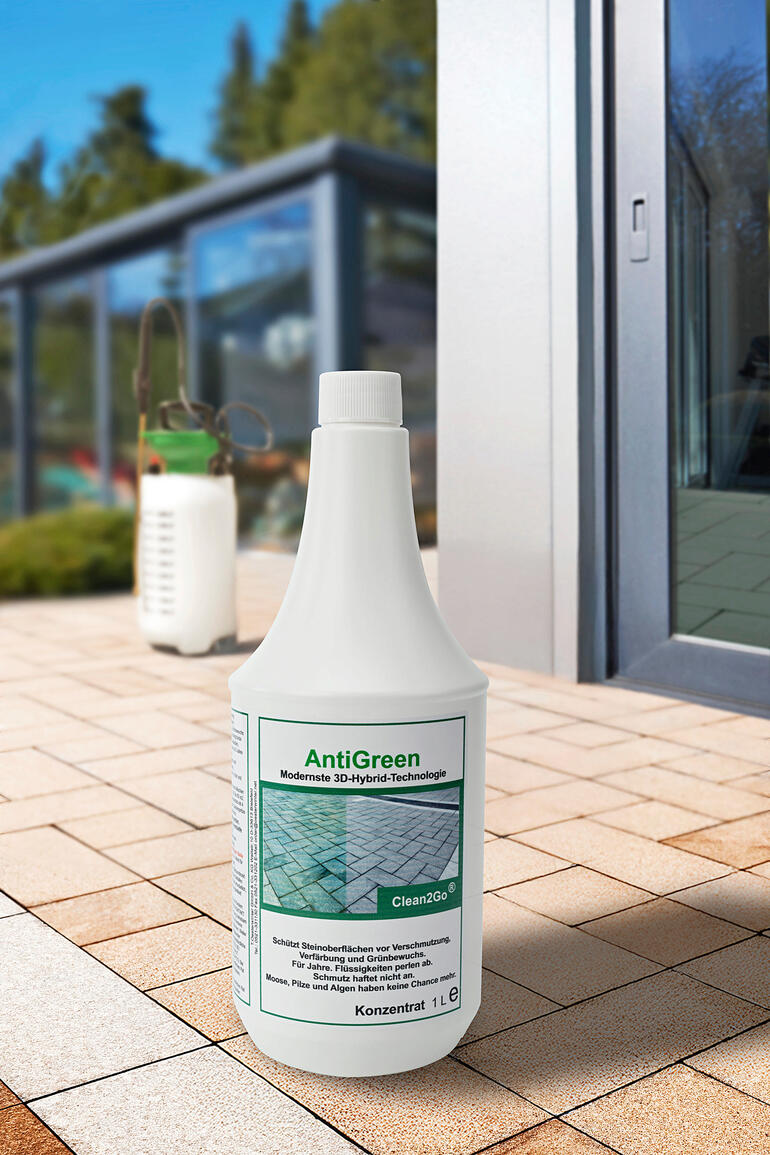 Flasche AntiGreen, 1 Liter Konzentrat auf einem Pflasterboden