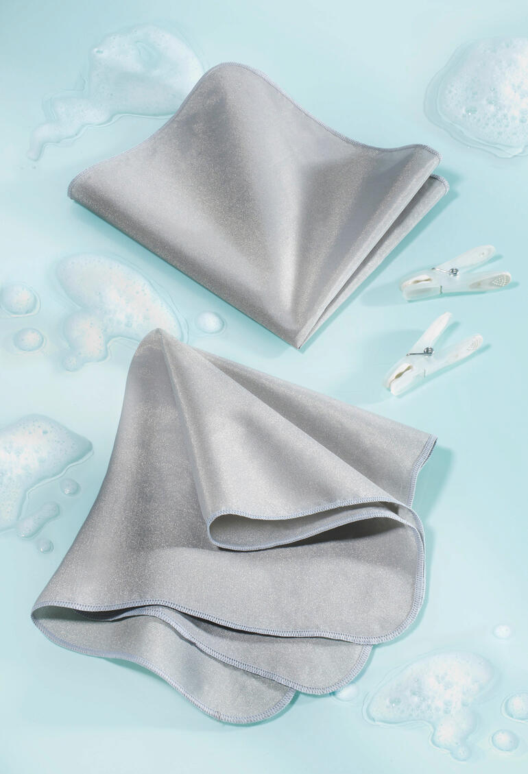 SilverWash®-Waschmaschinentuch in grau auf aquablauem Hintergrund