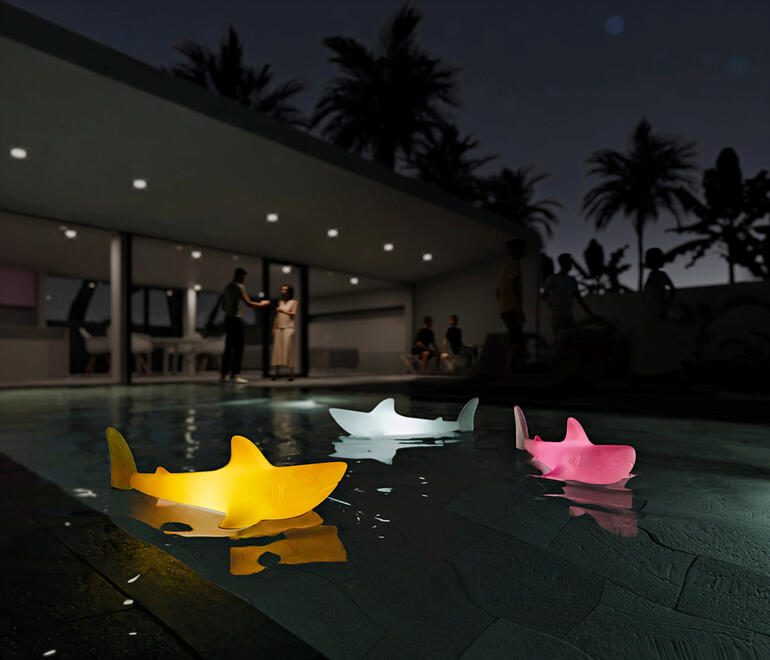 Bunte Hai-Leuchten schwimmen im Pool bei Nacht