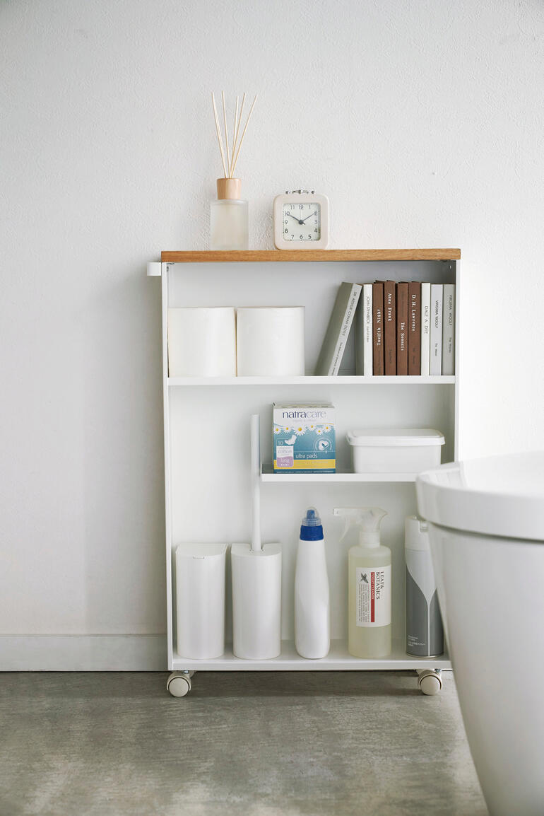 Mit der offenen Seite nach vorne ausgerichtet haben Sie alles im Blick und griffbereit. WC-Schrank mit offenen Regalen und verschiedenen Produkten