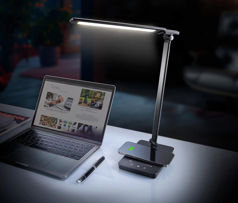 Dynamische LED-Schreibtischleuchte auf einem Schreibtisch neben einem Laptop