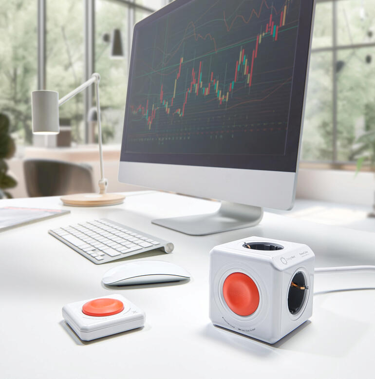 PowerCube Remote Set auf einem Schreibtisch mit Computer und Zubehör.