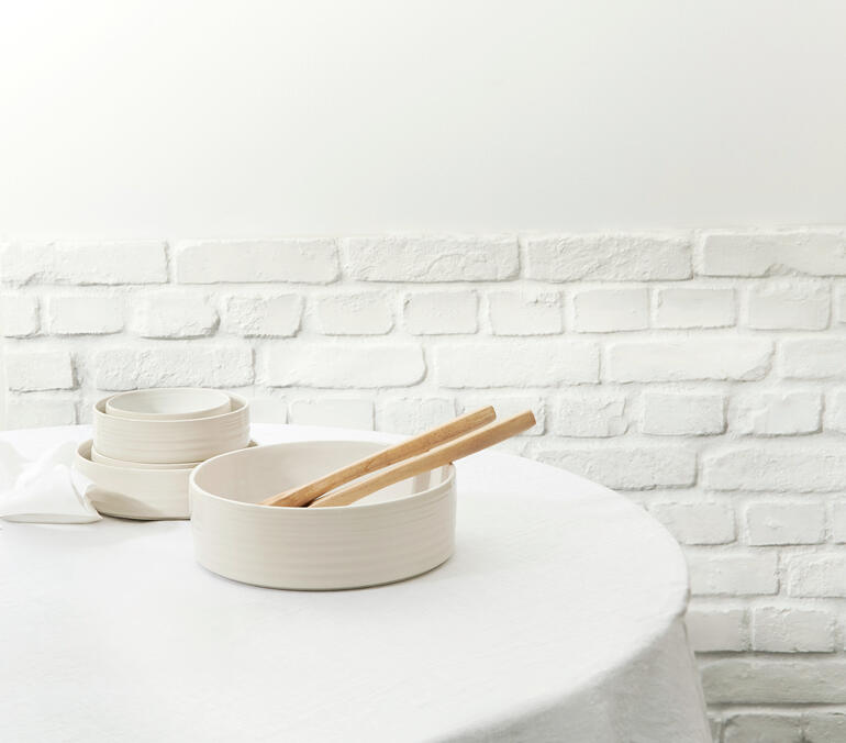 Reglaze Essteller 6er-Set in einer Schüssel auf einem Tisch mit einer Wand im Hintergrund.